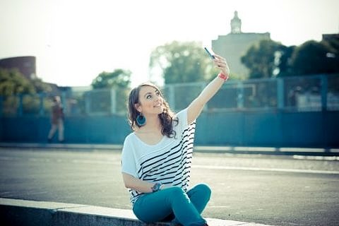 young beautiful brunette woman selfie with smart phone